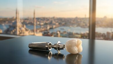A photorealistic close-up of a complete dental implant, including a titanium screw and a white ceramic crown, resting on a clean surface. The background is a heavily blurred, out-of-focus view of a modern city in Turkey during a sunny day.