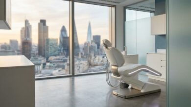 A serene and modern dental clinic room with an empty patient chair, overlooking a blurred UK city skyline through a large window.