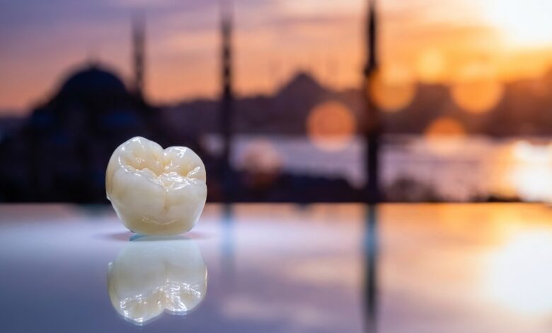 A photorealistic close-up of a flawless dental crown on a sterile surface. In the heavily blurred background, the sun rises over the Istanbul, Turkey skyline, creating a warm and inviting atmosphere.