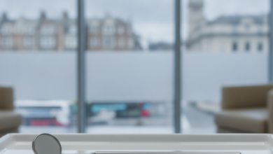 Close-up of clean, sterile dental instruments, including a mirror and a probe, resting on a white tray in a bright and modern dental clinic. The background is softly blurred, showing a subtle urban landscape typical of the United Kingdom through large windows.