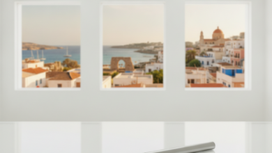 A close-up, sharp image of a modern, polished dental tool on a sterile white surface in a high-tech dental clinic. In the blurred background, a sunny Mediterranean cityscape with historical architecture is visible.